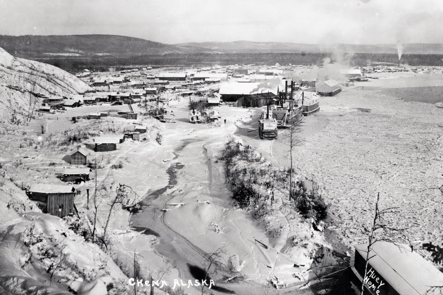 Aerial view of steamboats moored on shoreline of river in winter time.