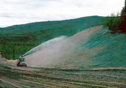 Hydroseeding a large-cut slope.