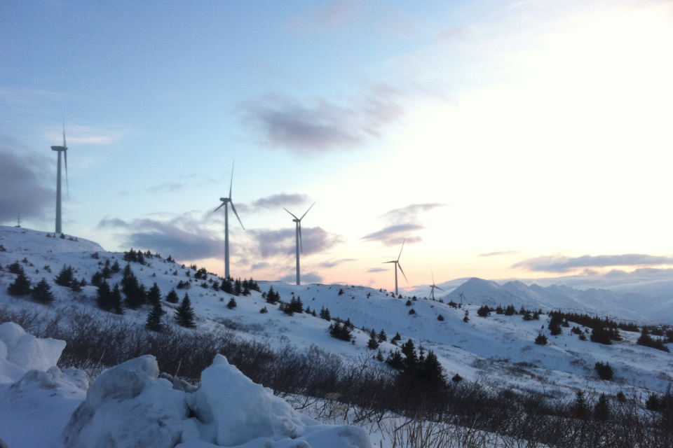Image of the Pillar Mountain wind turbines, the ground around them covered in snow. 
          Photo by AK Renewables, Decorative.