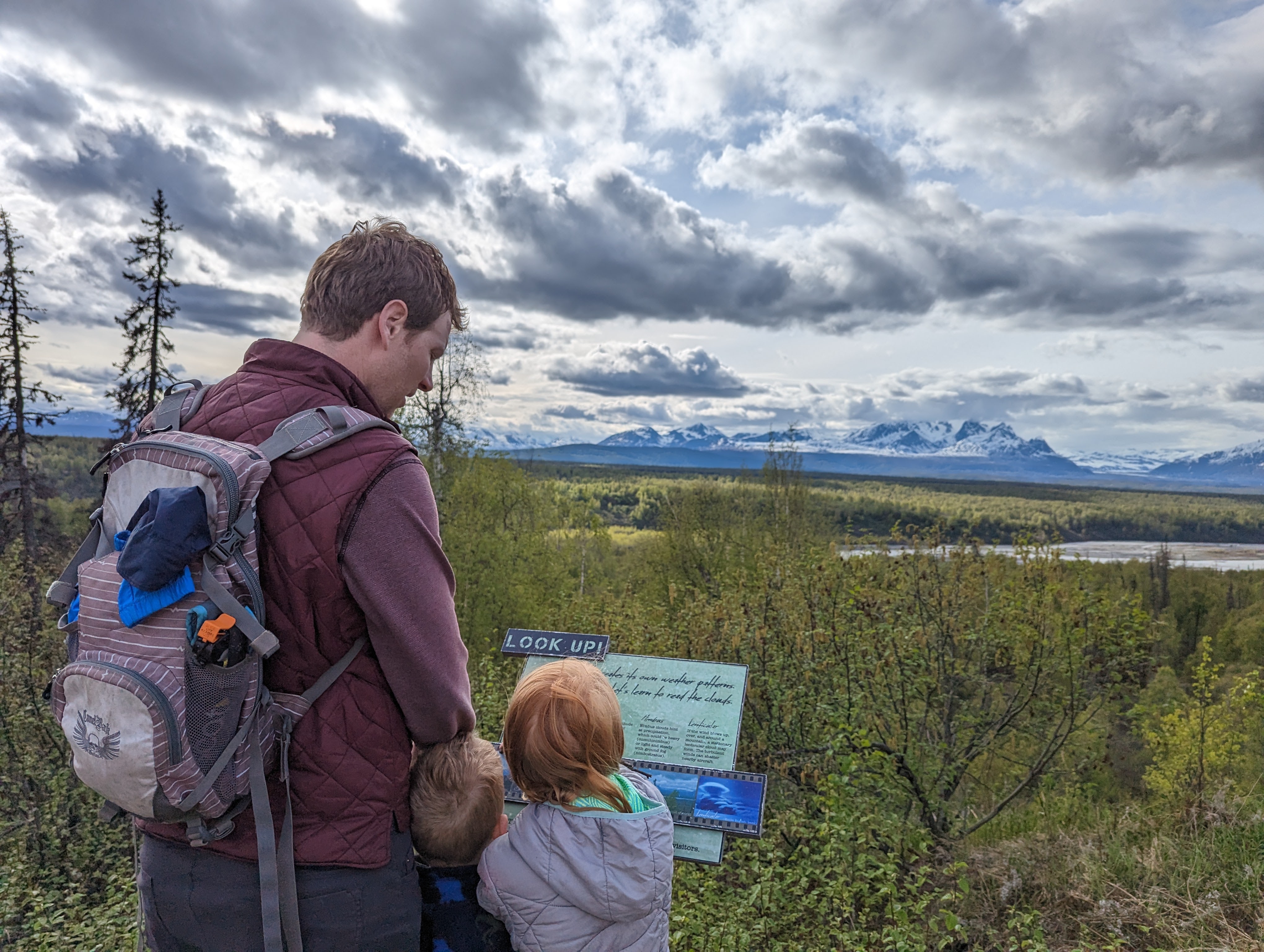 father and child look at interpretive panel in Denali State Park