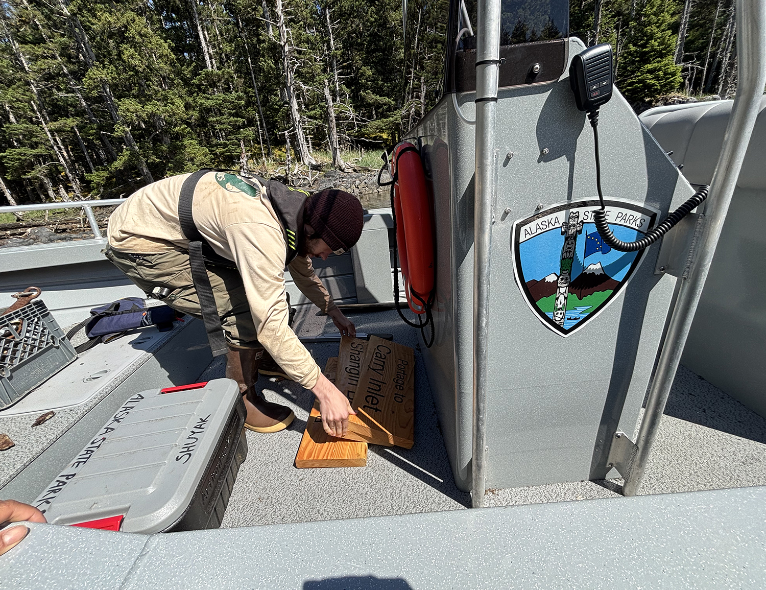ACC loading wood signs onto a Parks boat