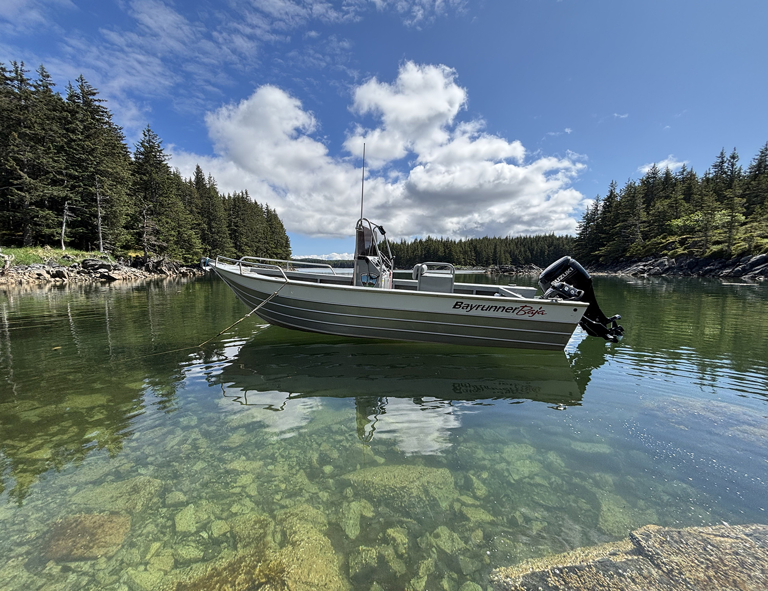 Parks staff small, single-motor boat anchored in shallows