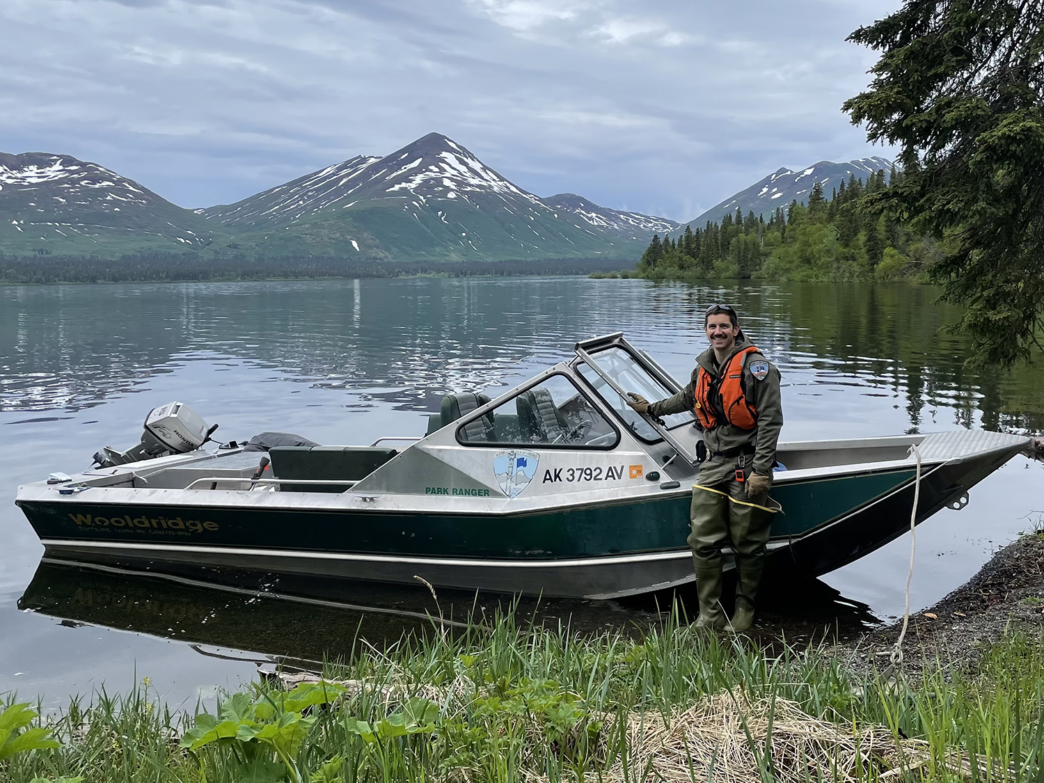 Superintendent and Ranger Ben Shryock next to a shored small boat.