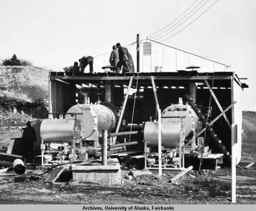 Soldiers working on portable boilers to supply U.S.Naval Station housing with heat, an official U.S. Navy photograph. Image courtesy of University of Alaska Fairbanks, Alaska and Polar Regions Collections, Alaska Earthquake Archives Committee Collection, UAF-1972-153-49.