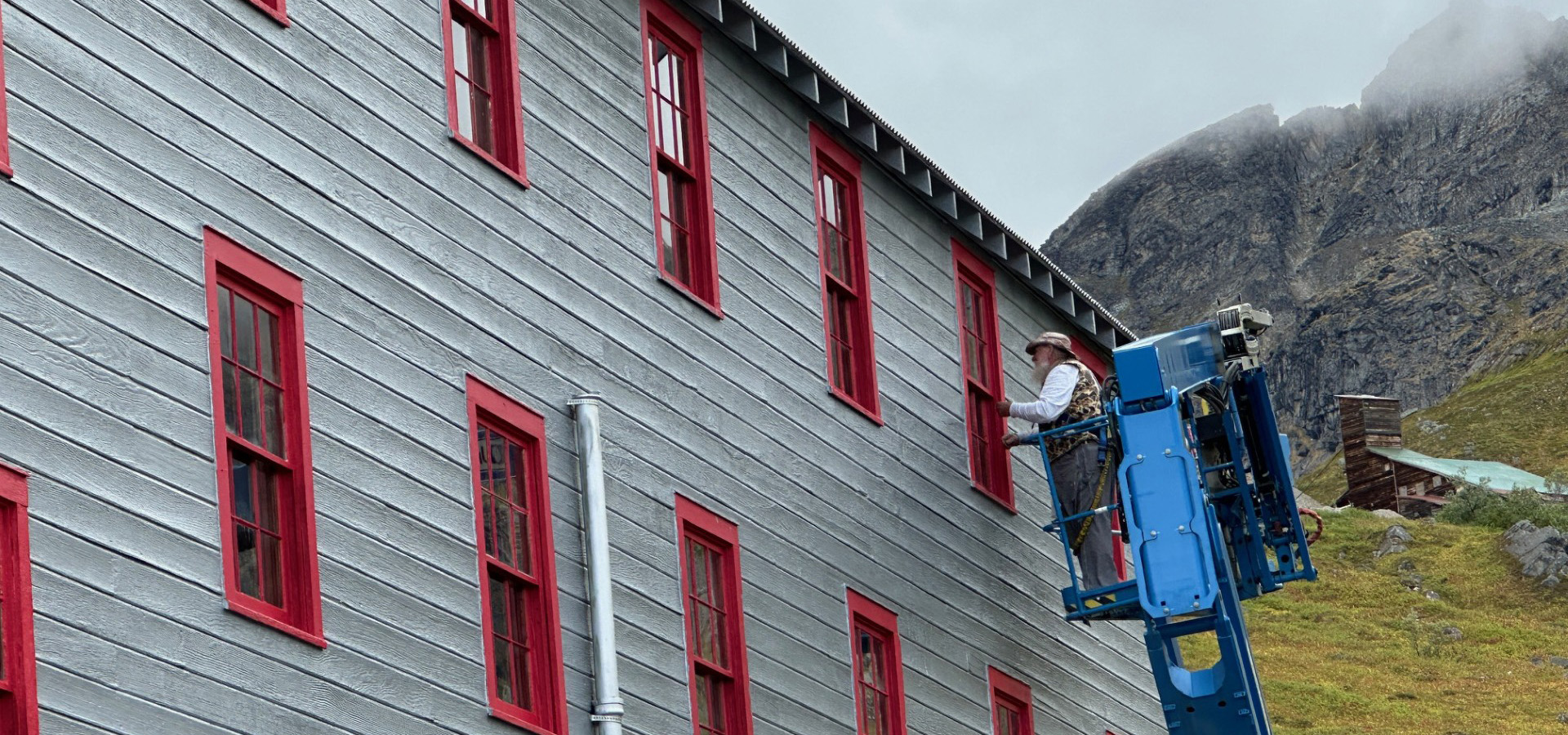 Independence Mine State Historical Park Rehabilitation, worker repairing a window from outside