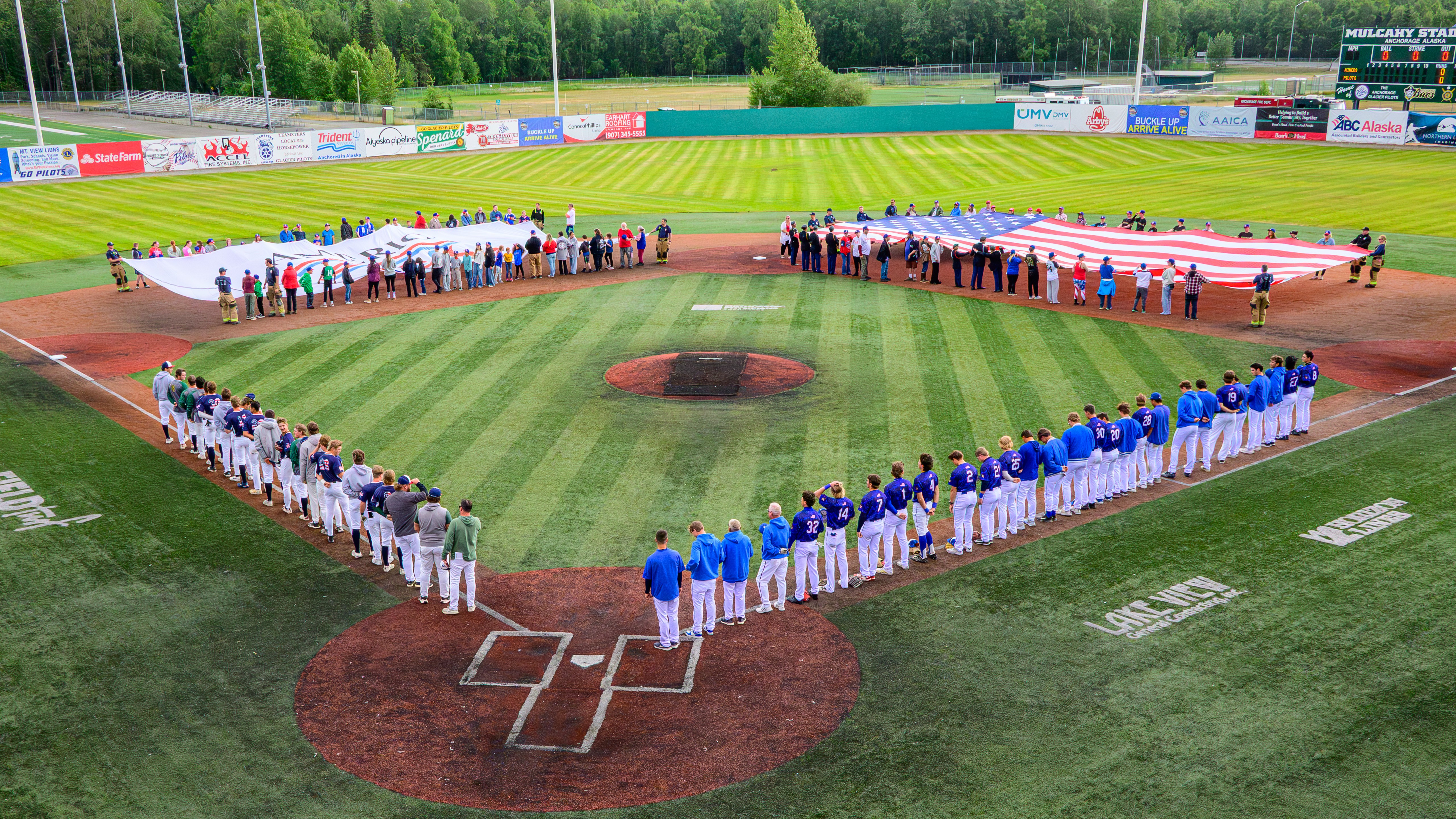 Baseball teams, flag holders on baseball field for pre-game anthem