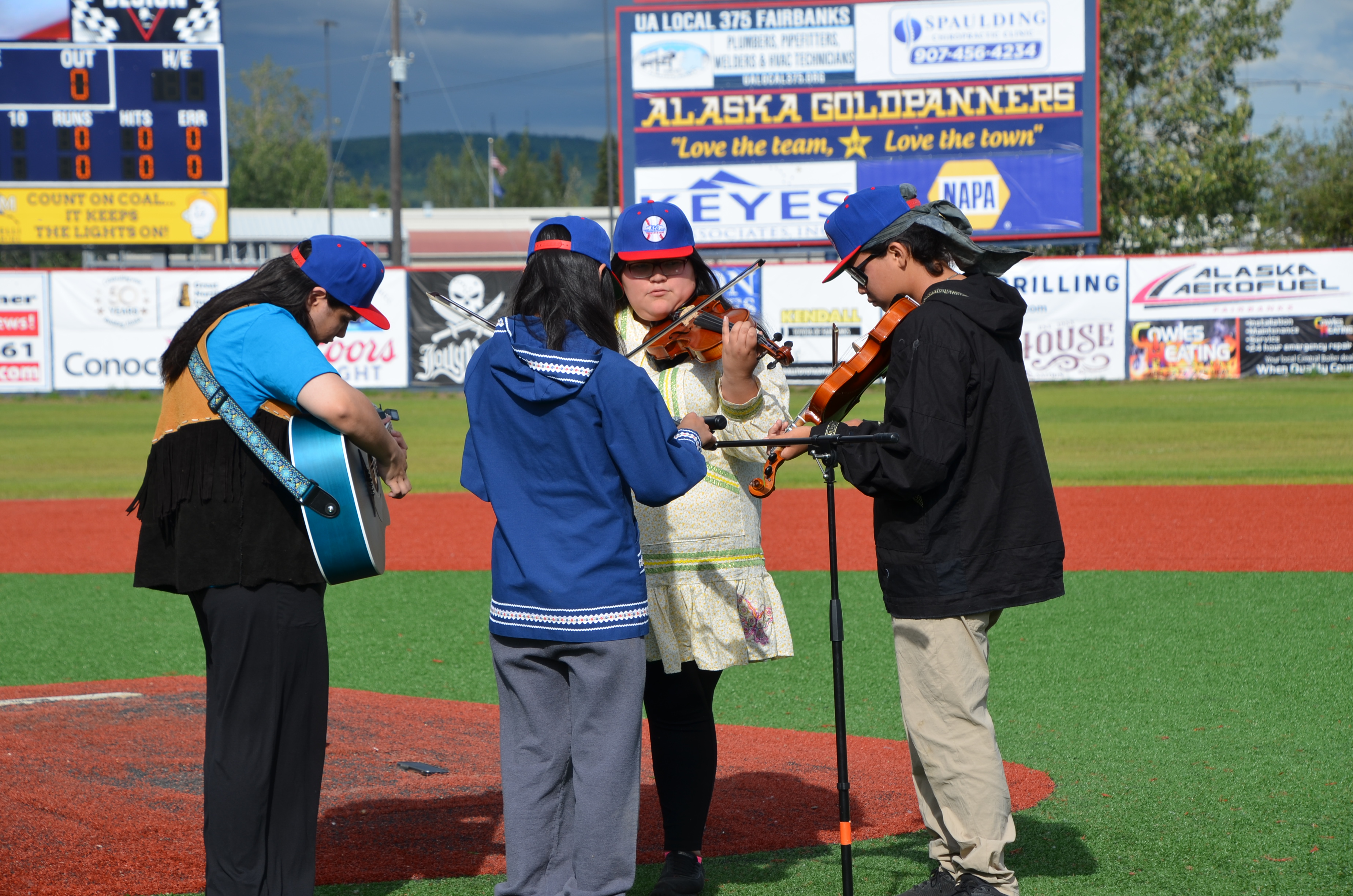 Alaskan musicians playing music at baseball game