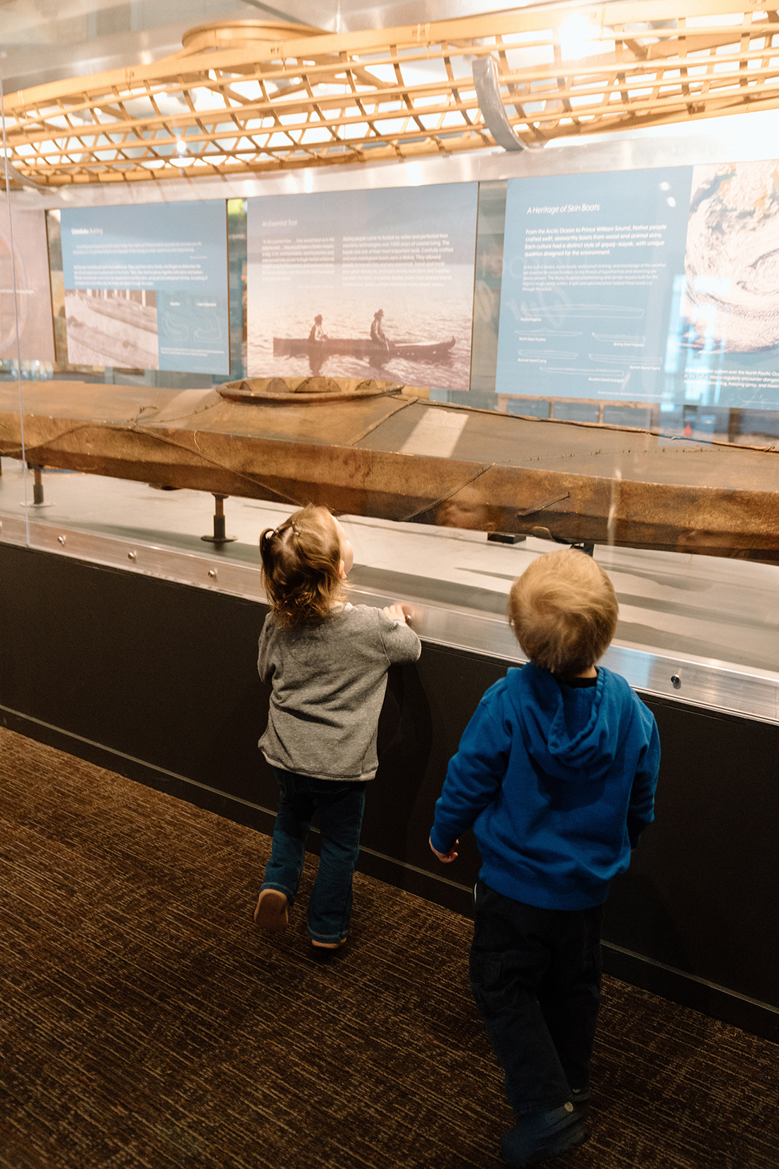 Two young children looking at Alutiiq museum display
